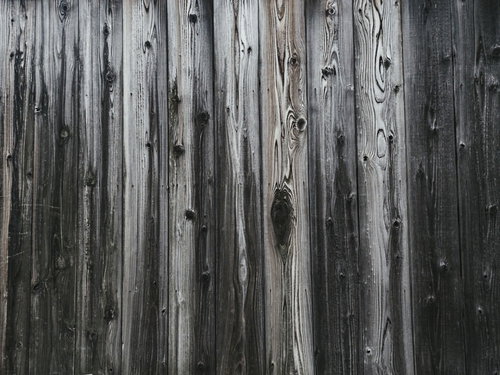 自然な木目が浮かぶ縦張りの古い板壁の経年テクスチャ