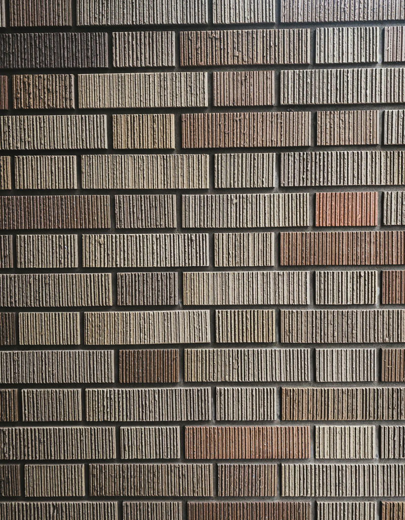 マンション入口に使用されているレンガ風の茶色いタイルの壁面