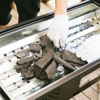 BBQ用の木炭をトレーで準備する様子の写真