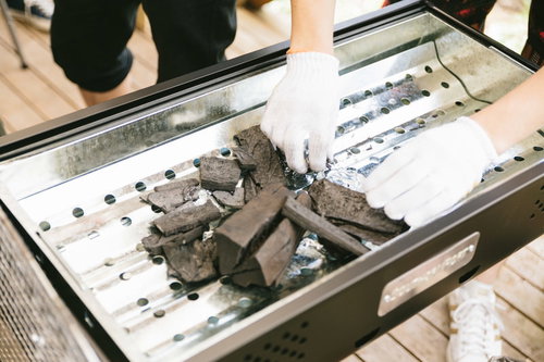 BBQ用の木炭をトレーで準備する様子