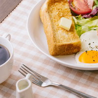 コーヒーとトーストの朝食プレート、白いお皿にバターとベーコンの写真