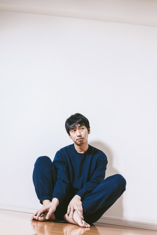 休日は昼までパジャマの男性が自宅でくつろぐ