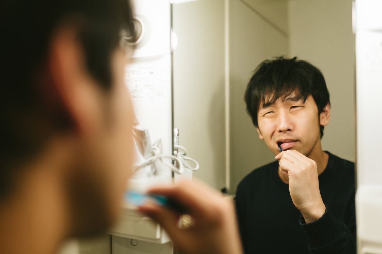 洗面台の鏡の前で歯磨き中にえずく男性［モデル：大川竜弥］