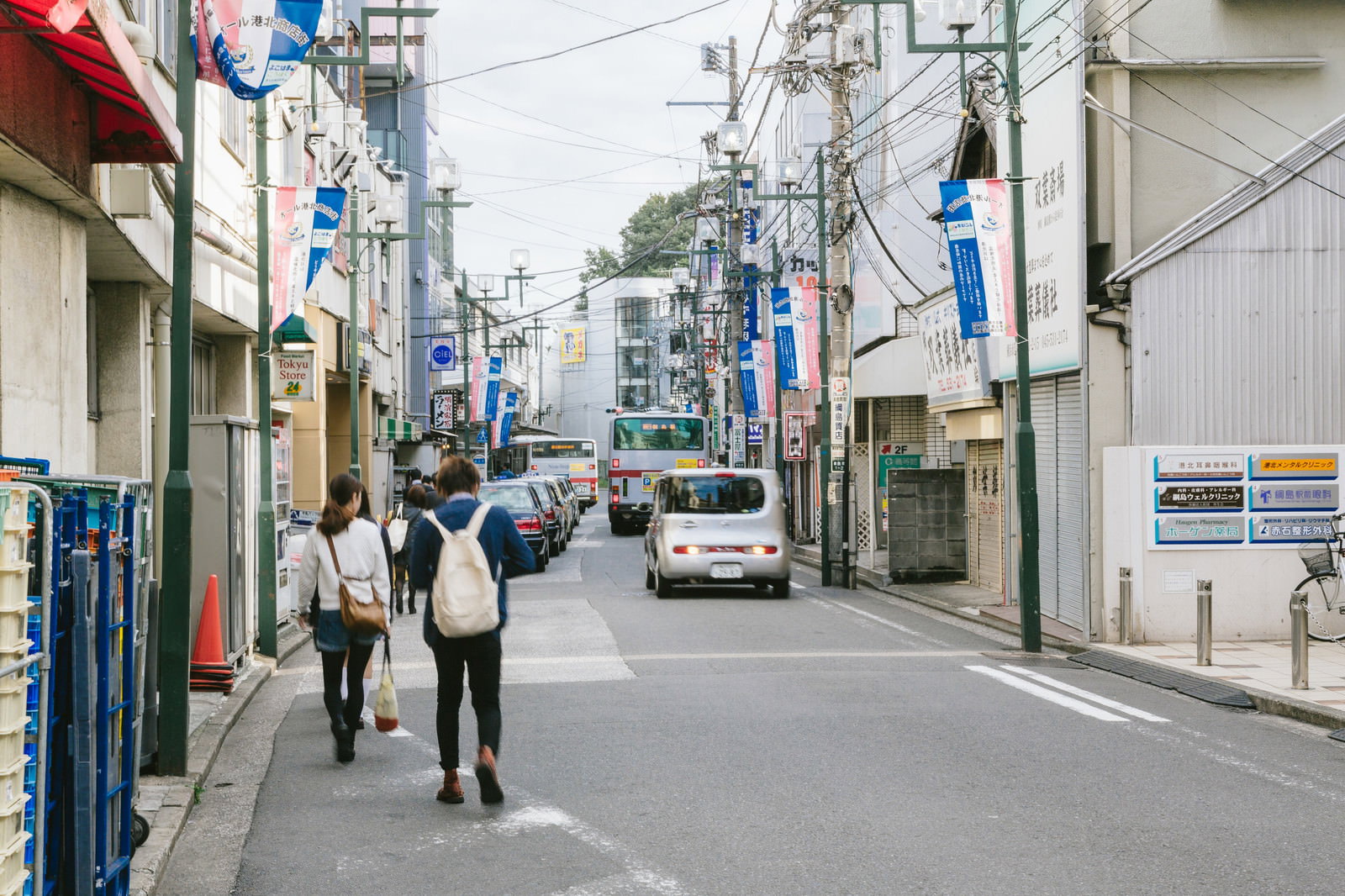 綱島駅前の商店街を歩く人々とバス