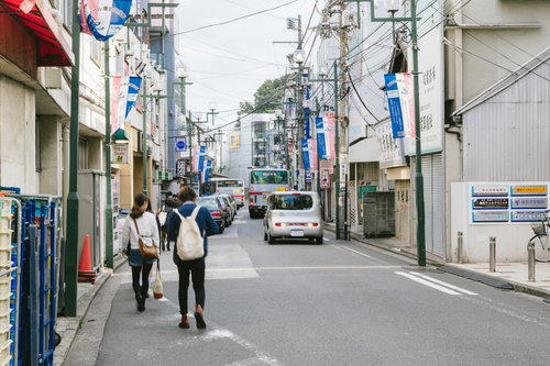 歩道がなく交通量も多い綱島駅前の商店街の風景