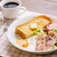 バターがのったトーストと目玉焼き、サラダの朝食の写真