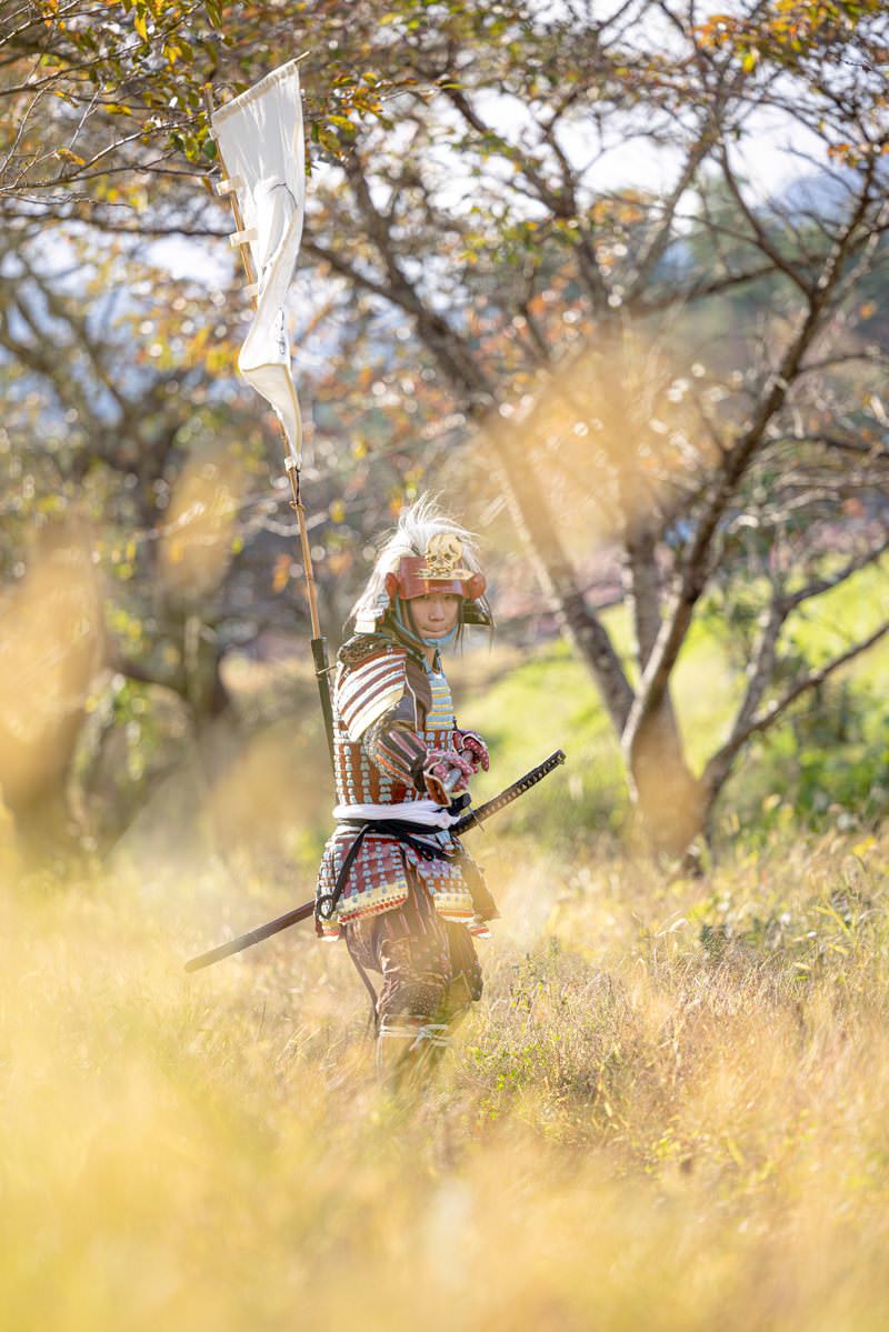 槍を構えた武将が枯れ野に立つ［モデル：まーこ］