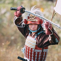 赤い当世具足を身に着け日本刀を構える侍の武士姿の写真