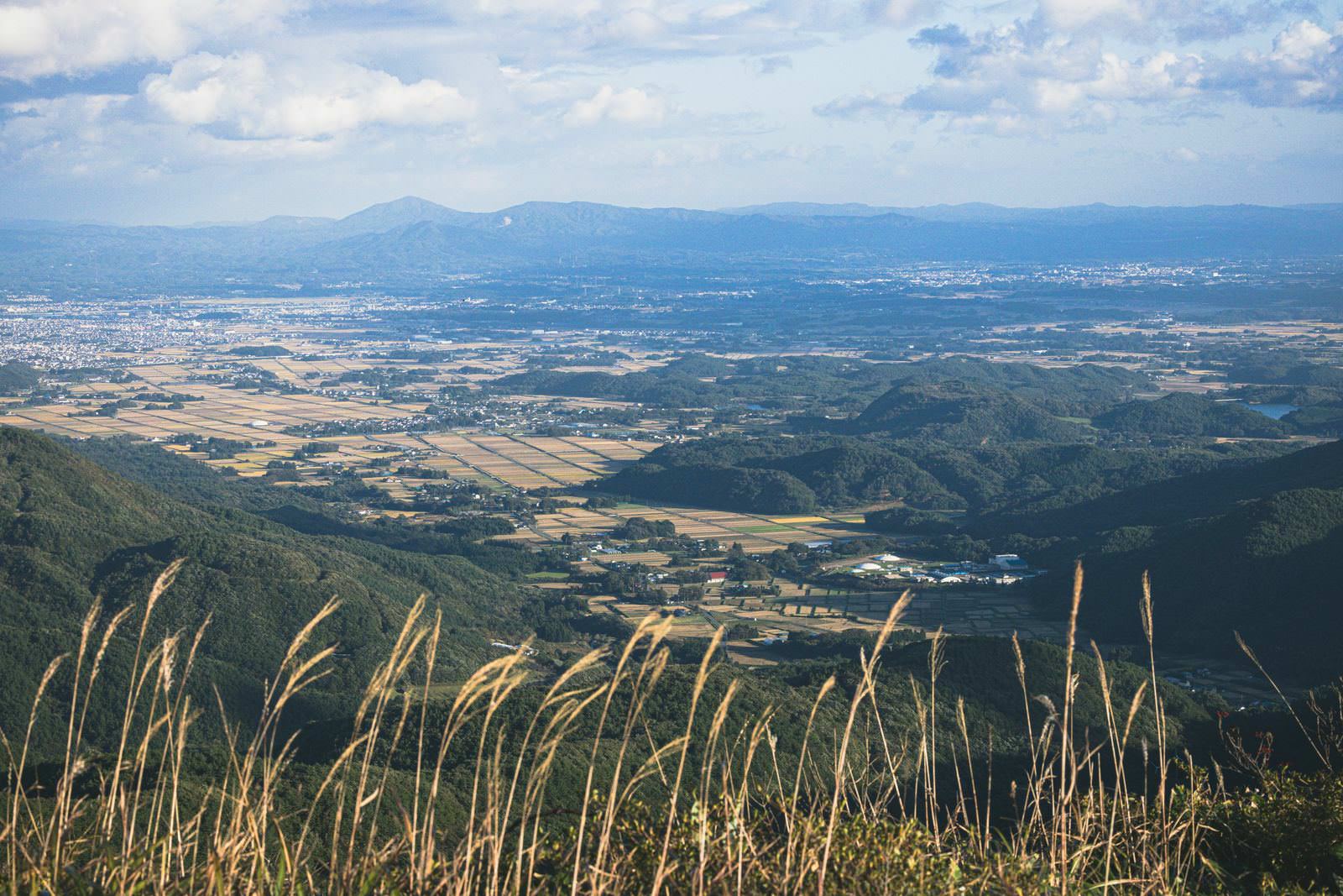 御霊櫃峠から見下ろす田園風景とススキ、遠方の山並み