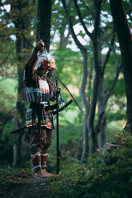 当世具足を身にまとい火縄銃に火薬を詰める武将