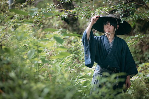 藪の中で周囲を警戒する袴姿の侍が刀を携えて身を潜める