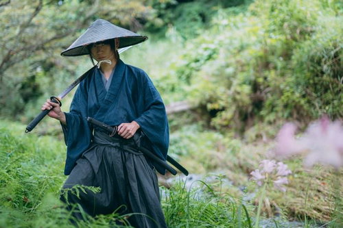 抜いた日本刀を肩にかける網代笠の武士の姿