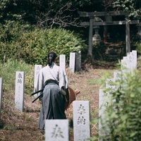 子授け桜の前を歩く袴姿の武士が参拝する神社の参道の写真