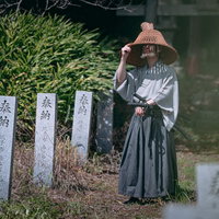 網代笠からこぼれる光と侍の姿、神社境内で撮影した和装男性の写真