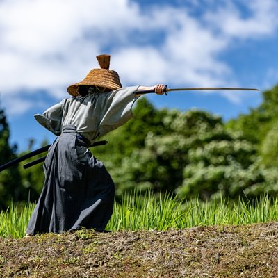 磐梯山を背に猪苗代湖の中州で二刀流をキメる大鎧武士の写真素材