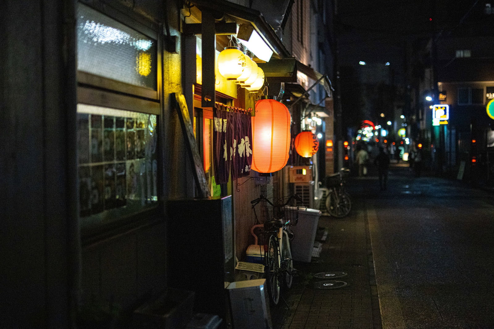 オレンジ色の提灯が灯る路地裏の居酒屋街の夜景