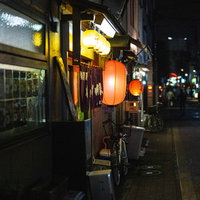 提灯が灯る路地裏の居酒屋の夜景と自転車のある日本の夜の写真