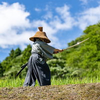 網代笠と黒い袴で日本刀を握り構える侍の用心棒の写真