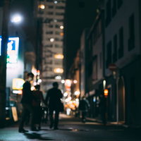 飲み明かして帰路に就く会社員の後ろ姿、夜の繁華街の路地裏の写真