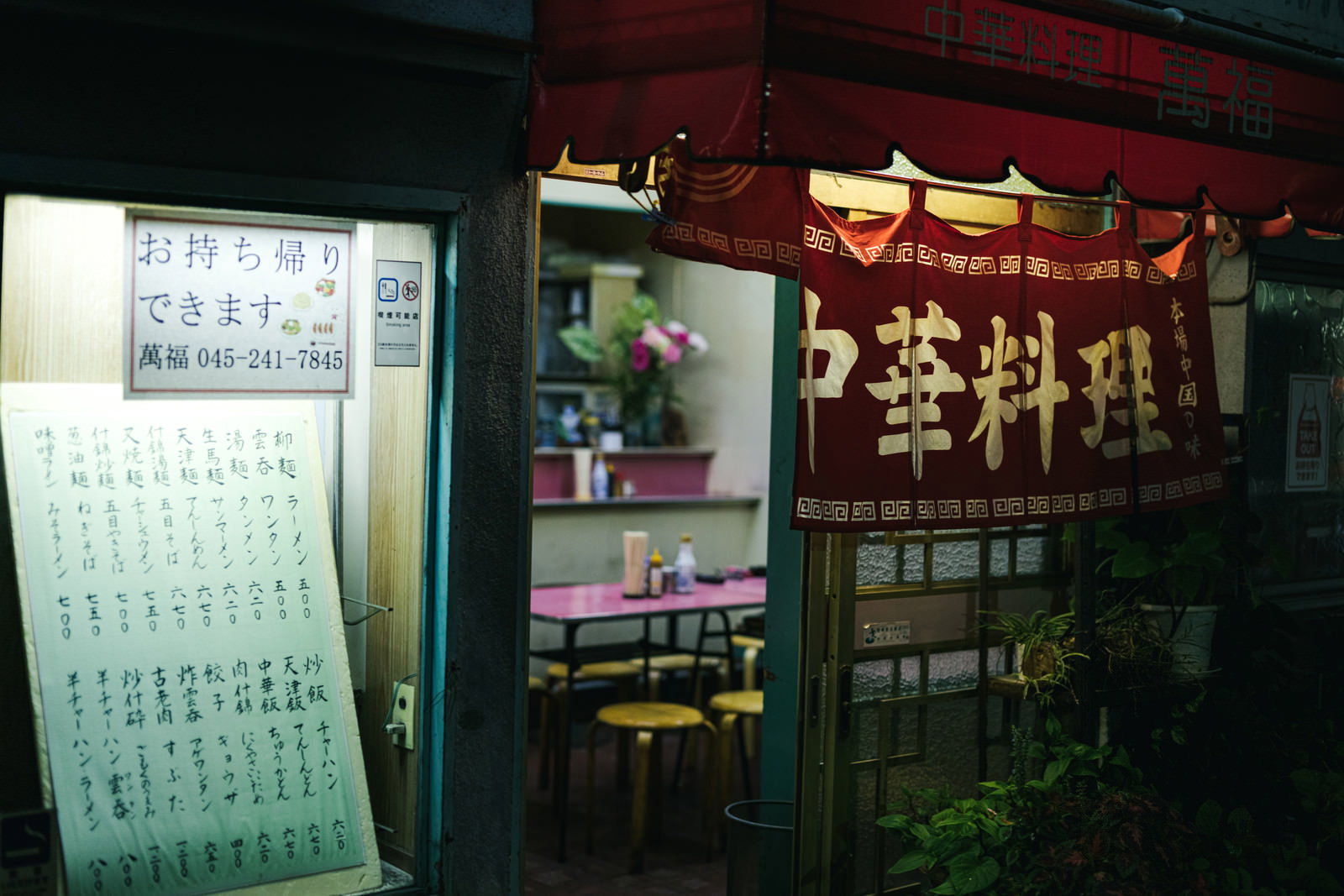 夜の中華料理店入口に並ぶのれんと品書き