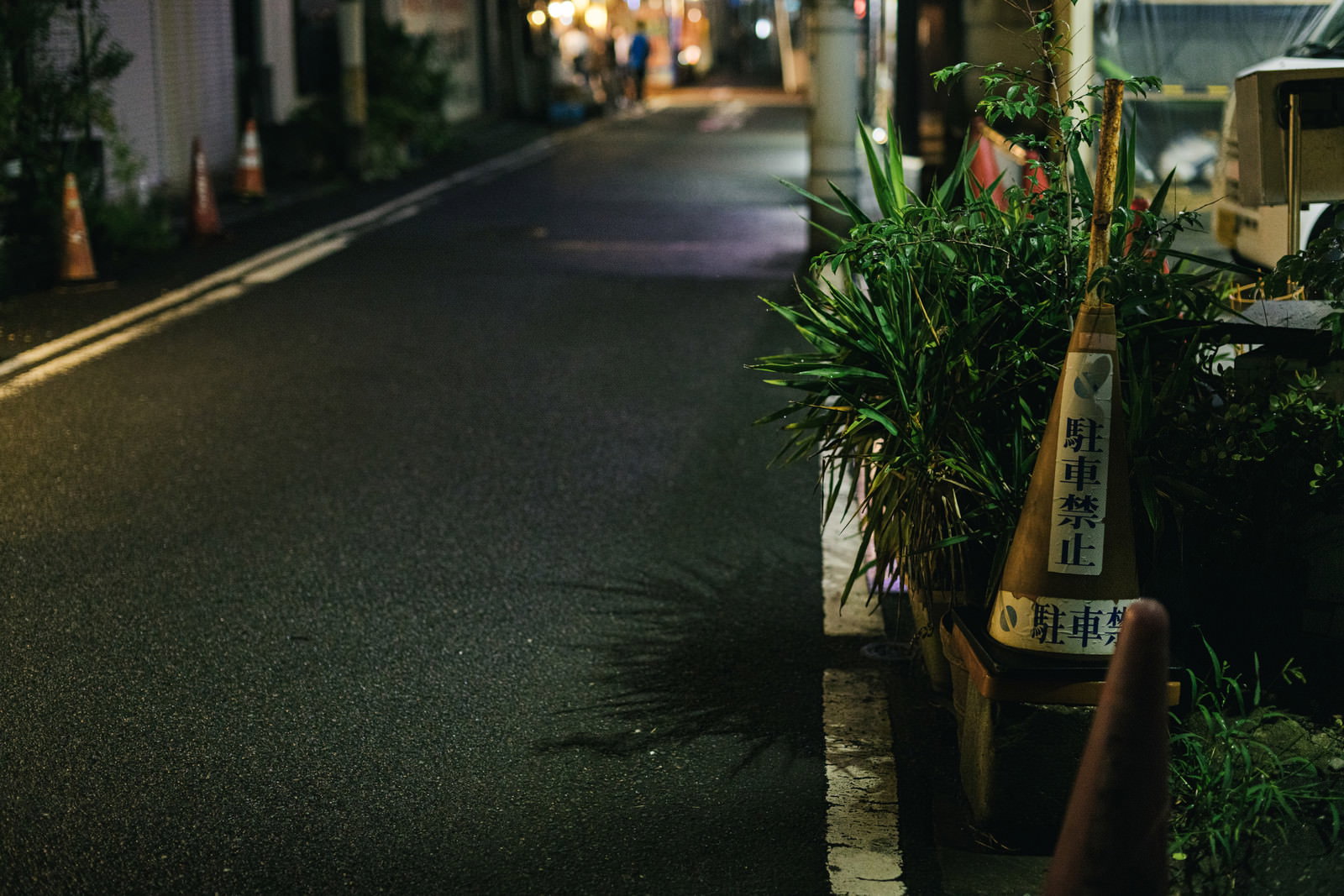 夜の路地に置かれた駐車禁止のオレンジ色のコーン