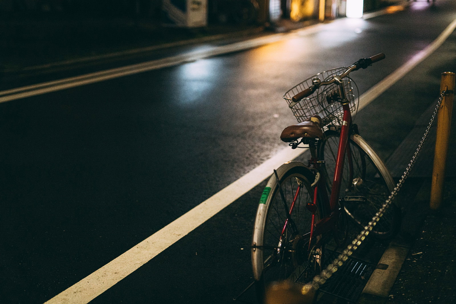 街灯に照らされて夜の道路に止められた自転車