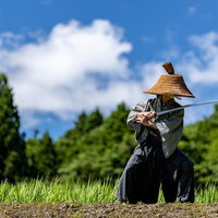 相手に向かって刀を構える網代笠の侍が戦闘態勢をとるの写真