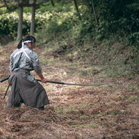 グレーの袴を着た侍が長巻を構える戦闘姿勢の写真