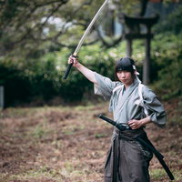 袴姿で日本刀を振り上げる侍の力強い構えと鍛錬の瞬間の写真