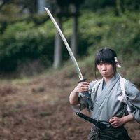 左手を腰に当て日本刀を手にする侍の凛々しい姿勢の写真