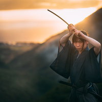 夕日を背に二本刀で上段の構えをとる侍のシルエットの写真