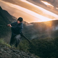 夕焼けに映える御霊櫃峠での刀を振り下ろした侍の写真