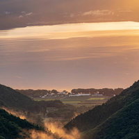 御霊櫃峠からの夕景に見る山間の景色と猪苗代湖の写真