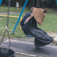 ブランコを漕ぐ網代笠の侍の写真