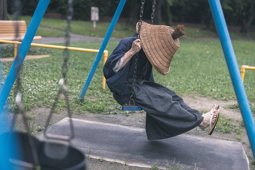 ブランコを漕ぐ網代笠の侍