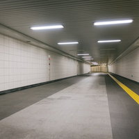 新宿三丁目駅構内E9出口に向かう白いタイル張りの地下通路の写真