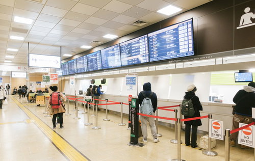 バスタ新宿の発券カウンターで列を作る乗客たち
