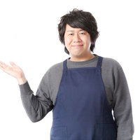 おすすめの品を案内するコンビニ店員男性の笑顔での接客対応の写真