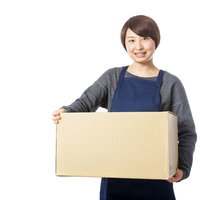 受け取りのサインを要求する紺色エプロンの宅配員の女性の写真