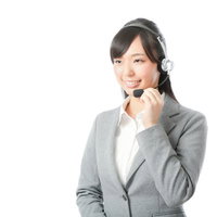 ヘッドセットを装着した笑顔のコールセンター女性オペレーターの写真