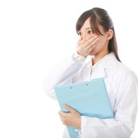 当直の予定を忘れていた研修医が口を抑えて驚くの写真