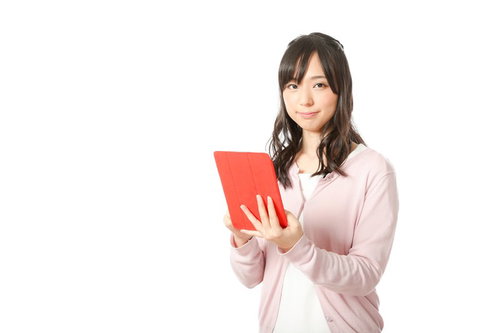 赤いタブレットで予定をチェックする広報女子