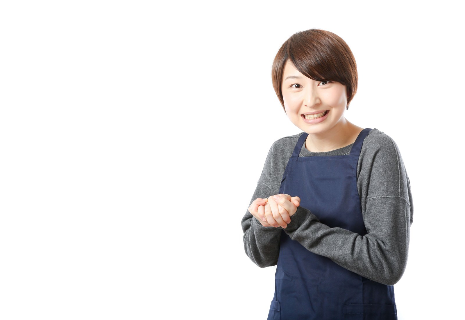 エプロン姿で両手を揉み合わせながら笑顔で商品をオススメする女性販売員［モデル：八木彩香］