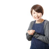 揉み手で商品をオススメする販売員のエプロン姿の写真