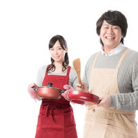 新しいレシピを開発し笑顔で調理器具を持つ食品メーカーの男女スタッフの写真