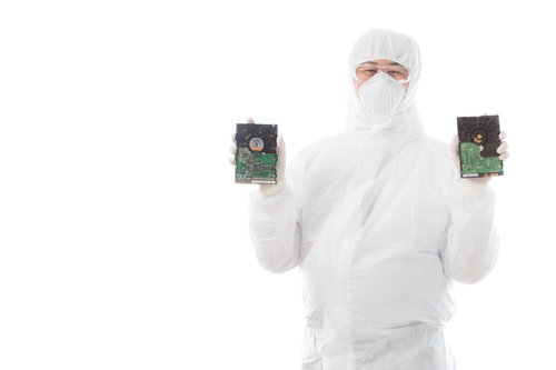 故障したハードディスクを手に持つデータ復旧エンジニア男性