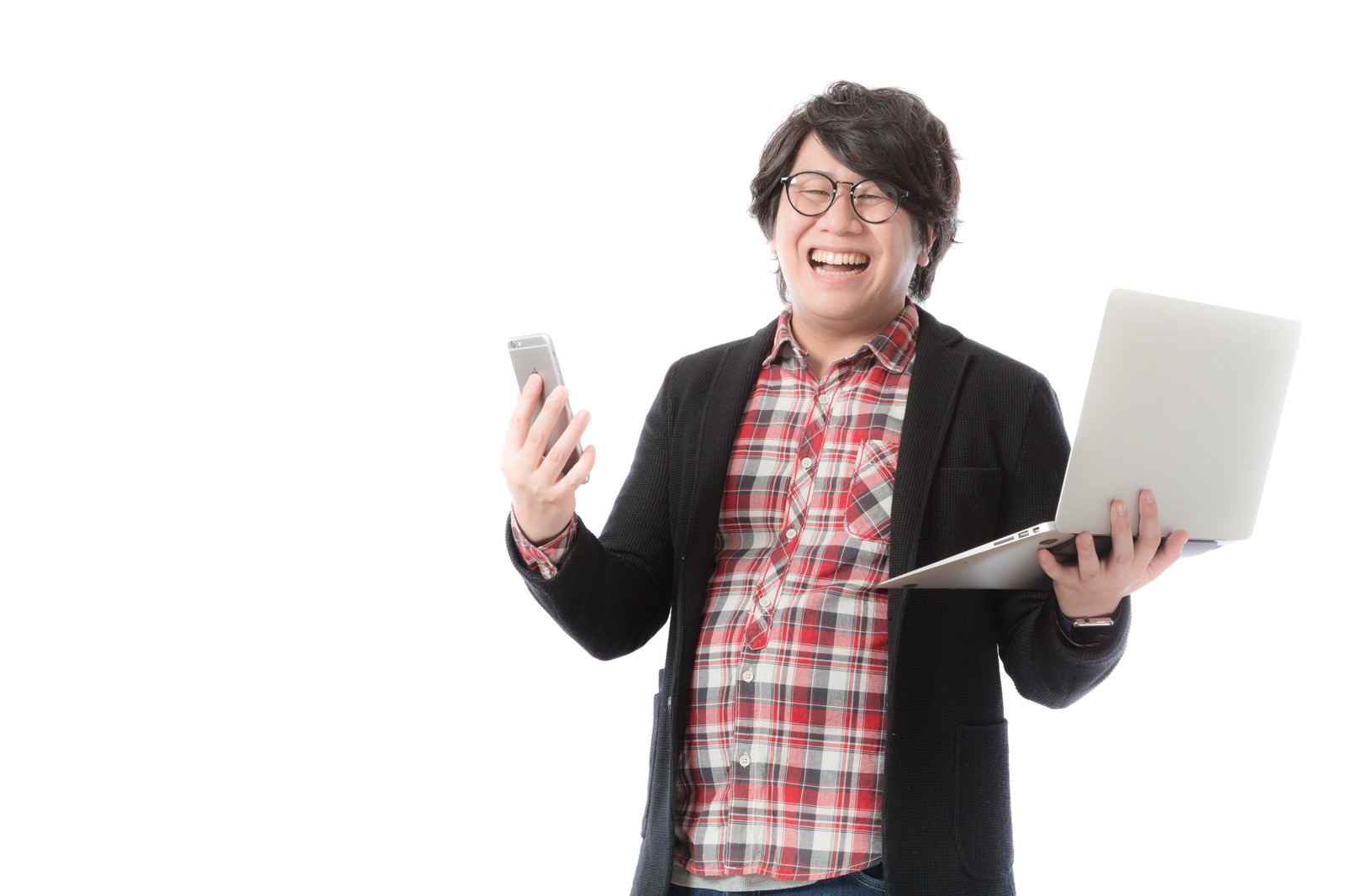 スマートフォンとノートパソコンを持って喜ぶWebデザイナー男性［モデル：あまのじゃく］