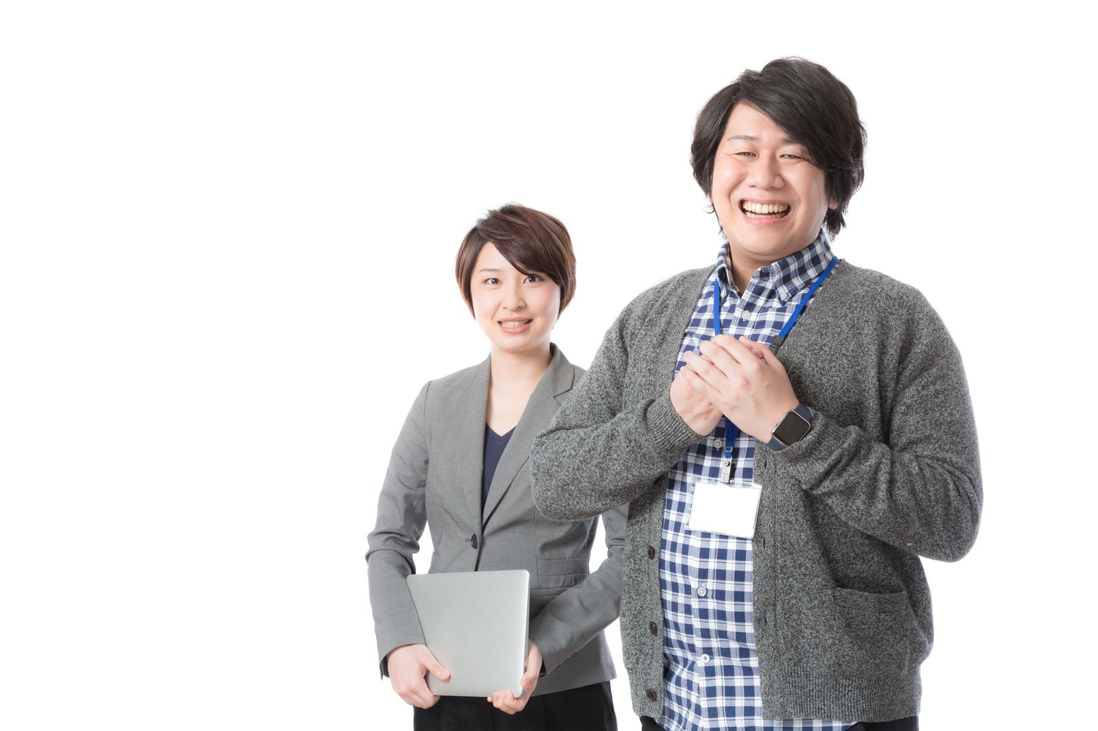 ノートパソコンを持つ女性スタッフと、IDカード装着の男性営業が笑顔で並ぶビジネスシーン［モデル：八木彩香 あまのじゃく］