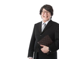 書類を手に満面の笑みで仕事を楽しむ法務部男性の写真