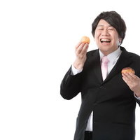 趣味を仕事にした菓子メーカー商品企画、シュークリームを食べて満面の笑みの写真